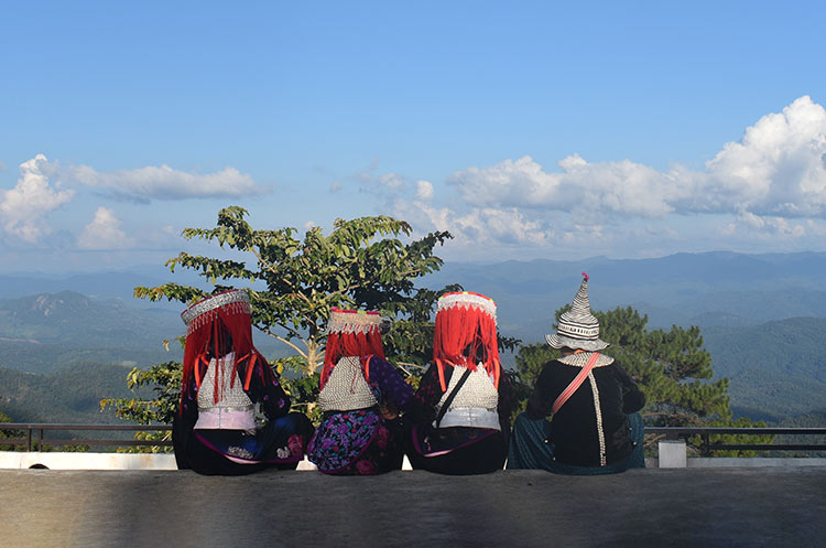 Hill tribes people in traditional dress overlooking the mountains of North Thailand