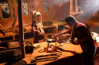 Hill tribe woman cooking a meal in a Akha hill tribes village