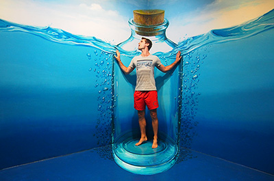 A young man seemingly stuck in a bottle at Art in Paradise