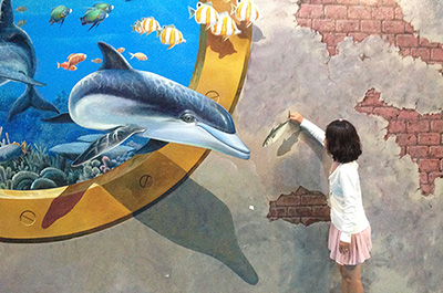 Feeding a dolphin in one of the art works at Art in Paradise Pattaya