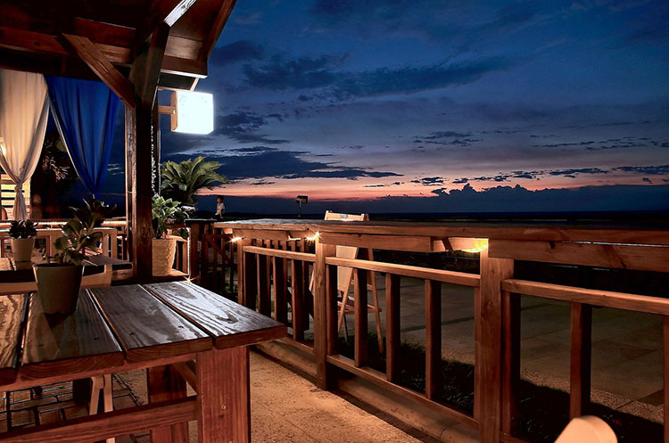 A restaurant overlooking the sea at sunset
