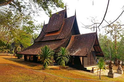 One of the dark teak wood buildings of the Black House in Chiang Rai