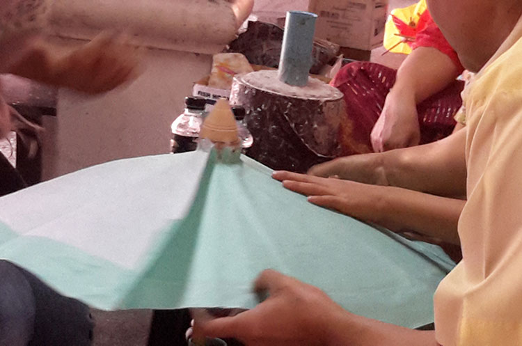 Craftsman at work producing a paper umbrella