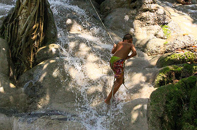 A boy climbing up holding a rope