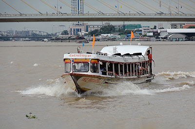 An orange flag boat of the Chao Phraya River Express Boat service on the river