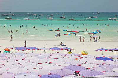 Beach with beach chairs and parasols at Koh Larn