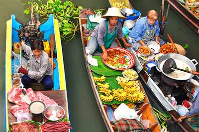Vendors selling fresh fruits and vegetables from their boats at Damnoen Saduak