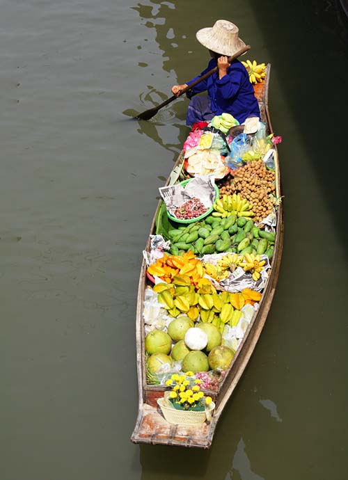 A seller pedalling her boat on the floating market canals