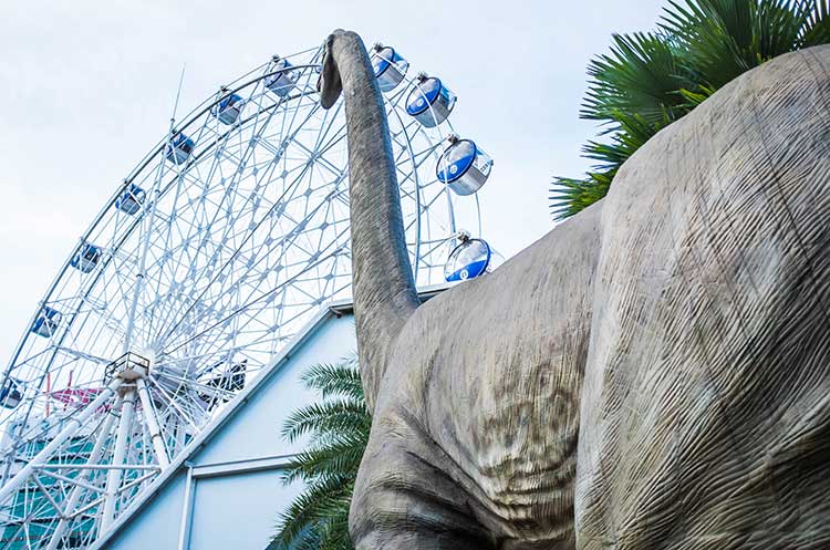 A gigantic dinosaur and the Dino Eye Ferris wheel at Dinosaur Planet