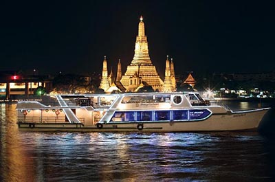 The horizon dinner cruise ship cruising past the illuminated Wat Arun