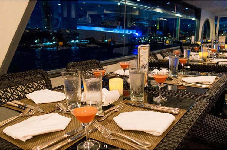 Set dinner tables on the Horizon dinner cruise ship overlooking the Chao Phraya river