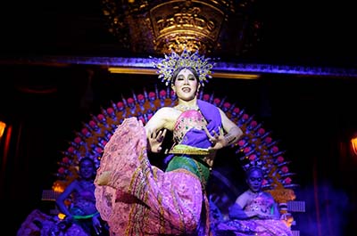 A dancer dressed in traditional dress performing an elegant Thai dance at the Junkyard Theatre Phuket