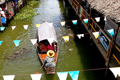 A boat with tourists navigating the narrow waterway at Klhong Lat Mayom
