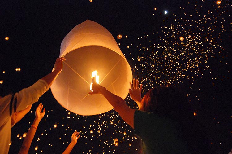 A sky lantern floating into the sky during the Yi Peng festival celebrations in Chiang Mai