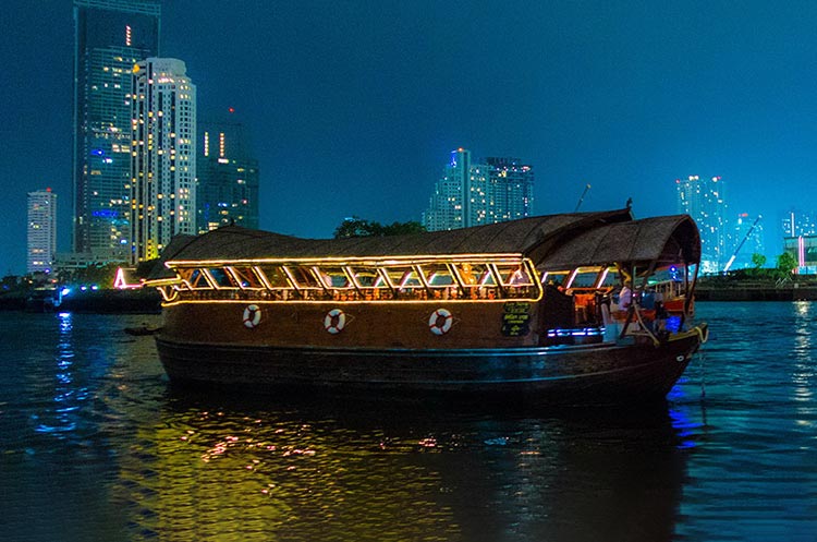 The wooden barge of the Loy Nava dinner cruise floating on the Chao Phraya river