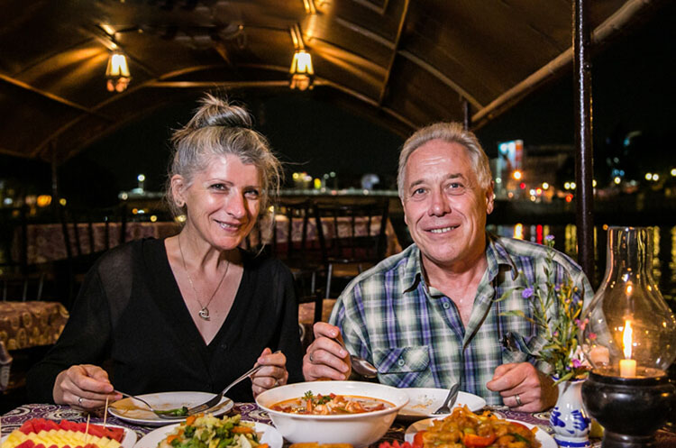 Two people enjoying Thai food on the Mae Ping dinner cruise boat