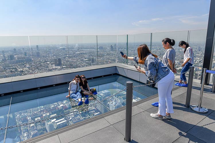 People on a glass floor 310 meters above ground, called The Glass Tray at Mahanakhon Skywalk