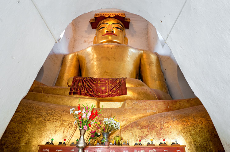 A large seated image of the Buddha inside the Manuha temple