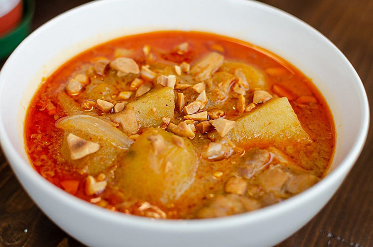A bowl of Massaman curry with chicken, potatoes and peanuts