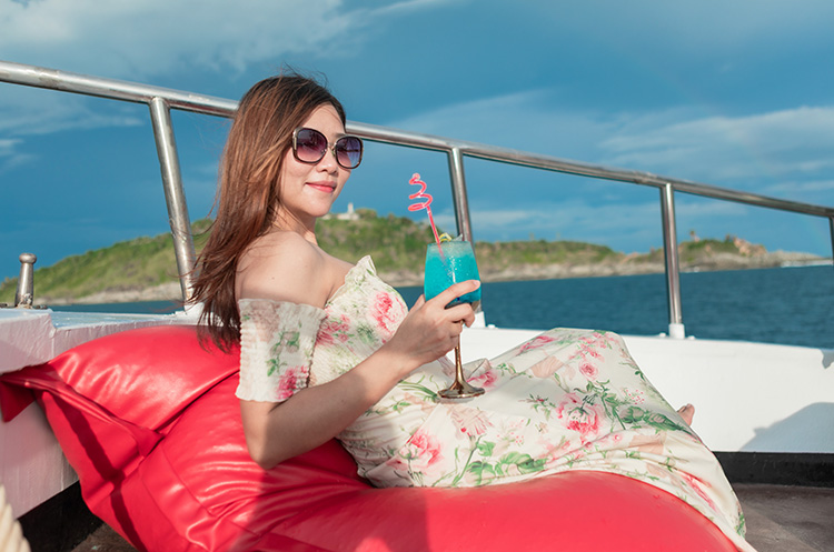 A woman enjoying a cocktail on the deck of the cruise ship