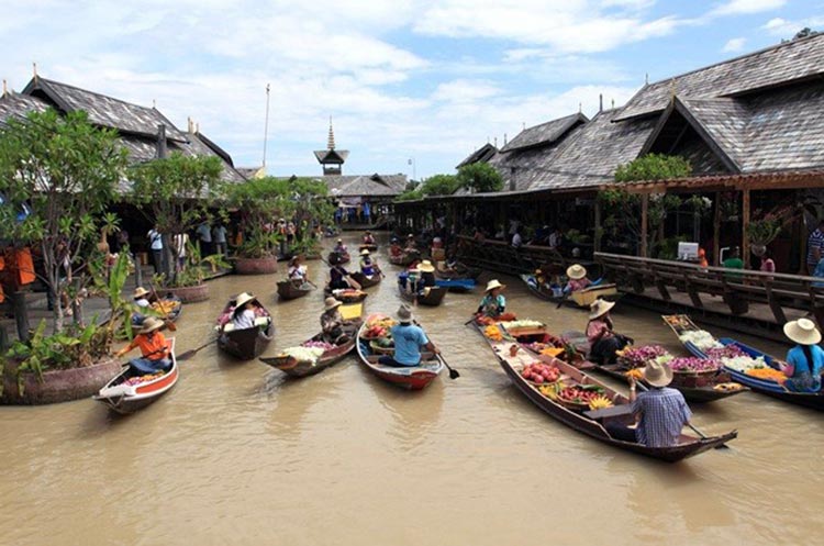 Vendors in small wooden boats on the canals of the floating market in Pattaya