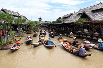 Vendors selling fruit and snacks on their boats at the waterways of Pattaya floating market