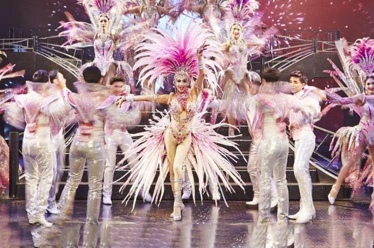 Glamorous dancers wearing extravagant outfits performing an act at the Simon Cabaret Show in Patong