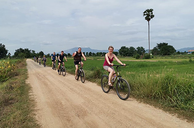 People on a bicycle in the countryside near Sukhothai Historical Park