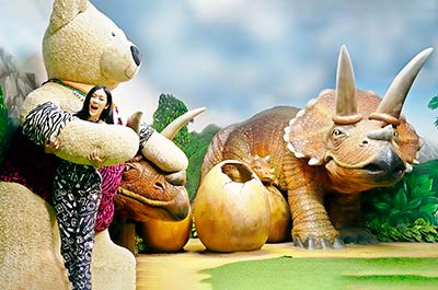 A woman posing with a teddy bear in the Dinosaurs Zone
