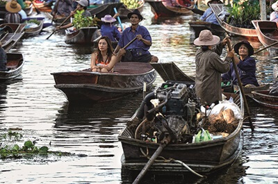 Vendors in boats on the canal of Tha Kha floating market