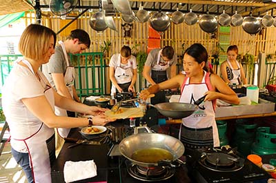 Teacher and students preparing food at the Thai Akha Cooking School in Chiang Mai