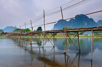 A wooden bridge across the river in Vang Vieng