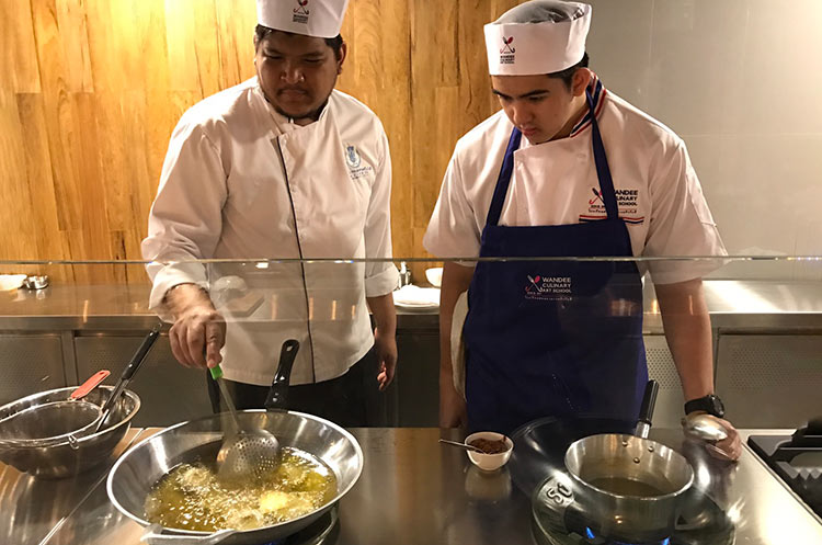 Student and teacher cooking a Thai dish at Wandee cooking school