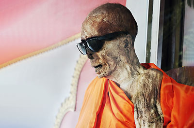 The mummified body of a monk on display in a glass casket