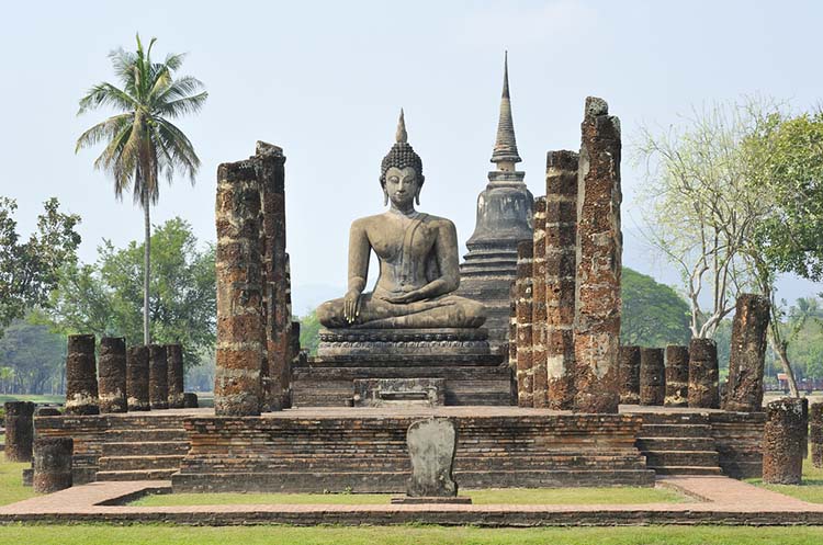 The remains of a viharn and a chedi in the background at Wat Mahathat
