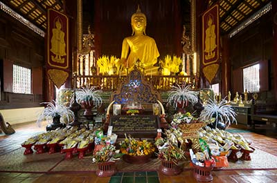The principal Buddha image in the teak wood assembly hall at Wat Phan Tao