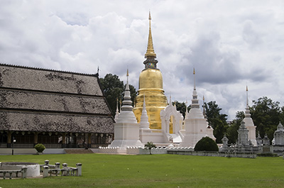 A large golden chedi and several smaller chedis at Wat Suan Dok in Chiang Mai